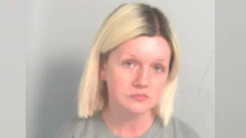 埃塞克斯警方：Virginia McCullough的拘留照片。她有浅金色头发和深色发根。她穿着灰色毛衣，目视前方。