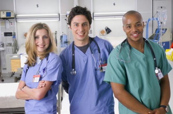  Sarah Chalke as Dr. Elliot Reid, Zach Braff as Dr. John 'J.D.' Dorian, Donald Faison as Dr. Christopher Turk on Scrubs set. They are stood in a hospital wearing scrubs